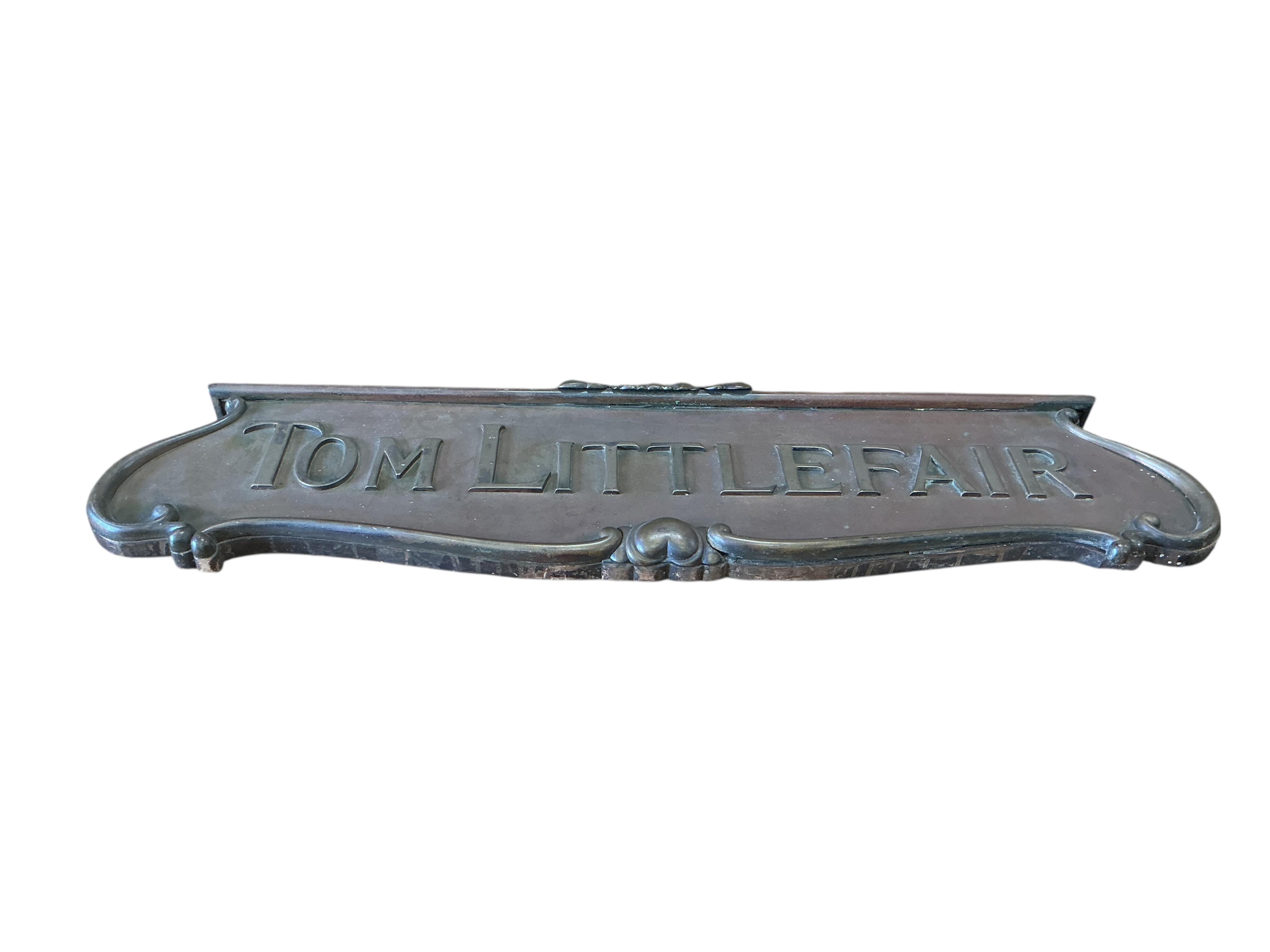 A cast brass 'Tom Littlefair' shop sign, width 104cm, height 27cm